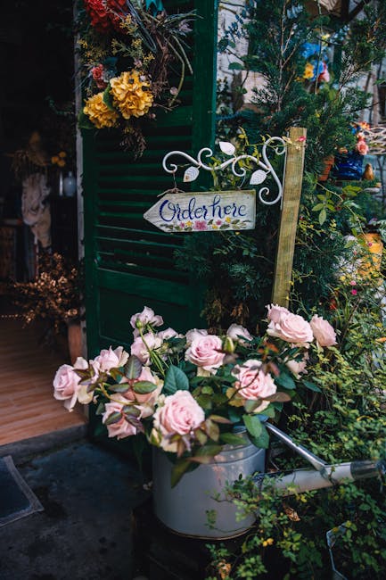 An outdoor display at croydonflorist.org.uk features a variety of fresh flowers arranged in an inviting garden setting. In the foreground, a bouquet of pale pink roses with lush green leaves sits in a